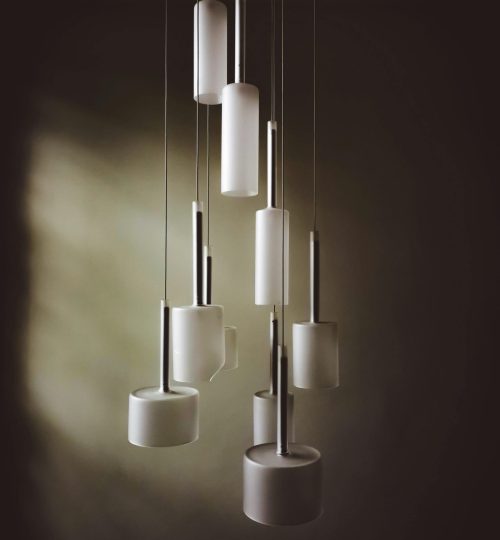 A close-up view of modern white cylindrical chandeliers hanging elegantly indoors.